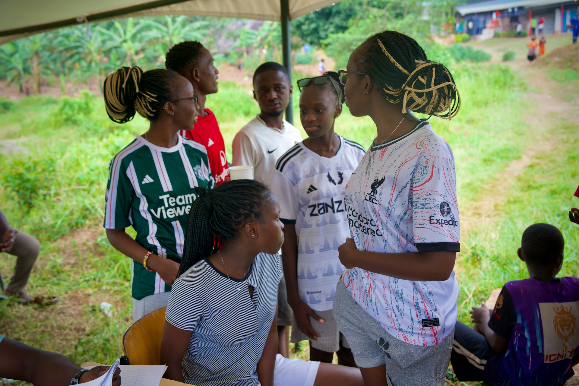 A group of young people stand together outside.